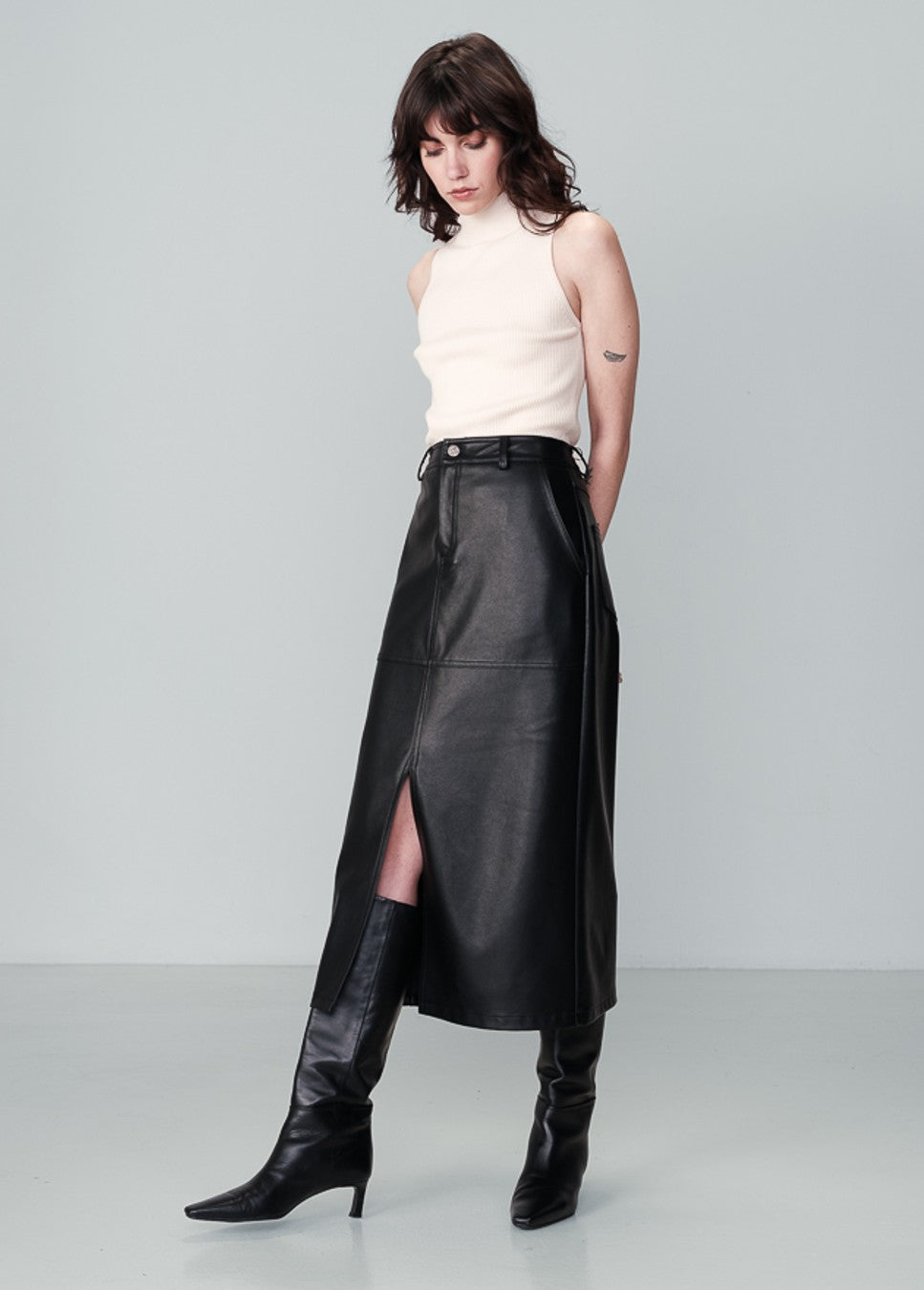 Zwarte vegan leren dames rok Nory grace & Mila mid rok op model zijkant staand