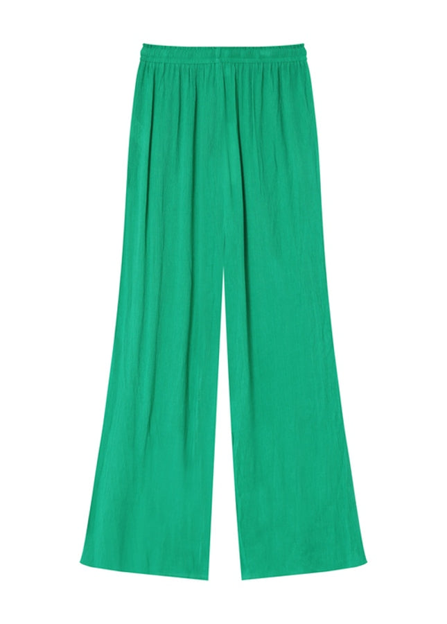 Groene pantalon Matisse van het merk Grace & Mila. De Matisse is een lange, wijde broek met een elastische taille met strikband en steekzakken aan de zijkant. De perfecte broek voor de warme zomerdagen. Combineer de groene pantalon met de bijpassende groene oversized blouse voor een comfortabele en elegante look. 